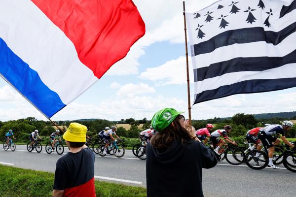 环法自行车赛的支持者手举法国国旗和布列塔尼旗帜(右)。(THOMAS SAMSON/AFP via Getty Images)