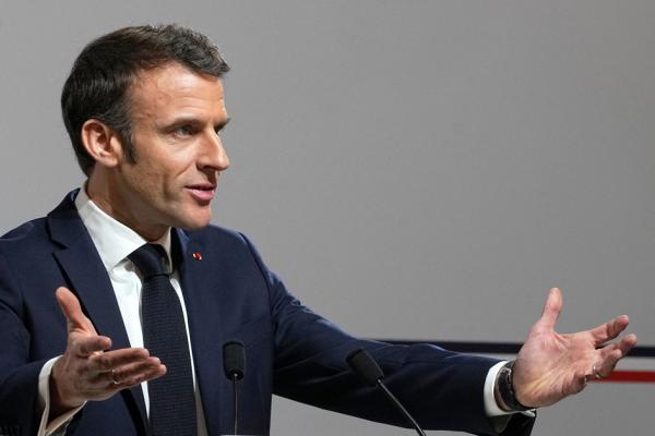 2023 年4月19 日,法国总统埃马克龙(左二)在访问位于法国东部塞勒斯塔市时在街上挥手致意。马克龙的退休改革在近几周招致了广泛的敌意。(LUDOVIC MARIN/POOL/AFP via Getty Images)