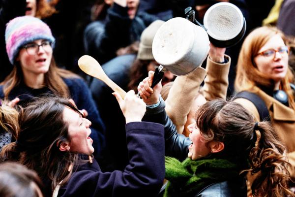4月17日马克龙电视讲话时,巴黎10区政府门口聚集了许多人以敲锅的方式抗议退休改革。( GEOFFROY VAN DER HASSELT/AFP via Getty Images)