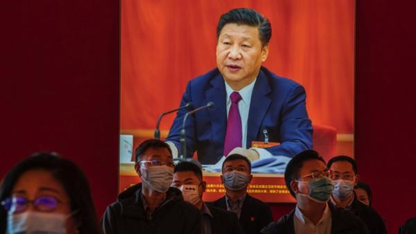 2022年10月12日,中共二十大前,党员们站在一幅习近平图片旁边,听导游介绍“伟大成就”。