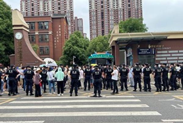 6月3日,湖北武汉市东湖高新区光谷第十五小学分流高年级的学生去三公里外的光谷第十九小学上学,引发上千家长抗议。(图片来源:翻拍网图) (图片来源:翻拍网图)