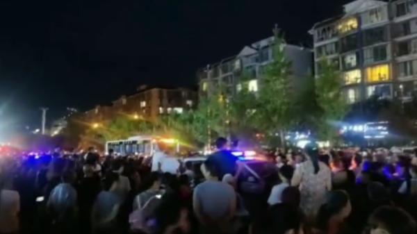 四川内江城管殴打商贩,引发大批民众团团围堵城管执法车。(图片来源:视频截图)