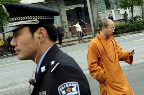 中共警方有1种新技术,只要有行人从身边走过,行人手机内的所有讯息,就会进入警察的手机内,警察马上知道行人这部手机号码的注册名字,微信群及聊天记录。(图片来源:MARK RALSTON/AFP via Getty Images)