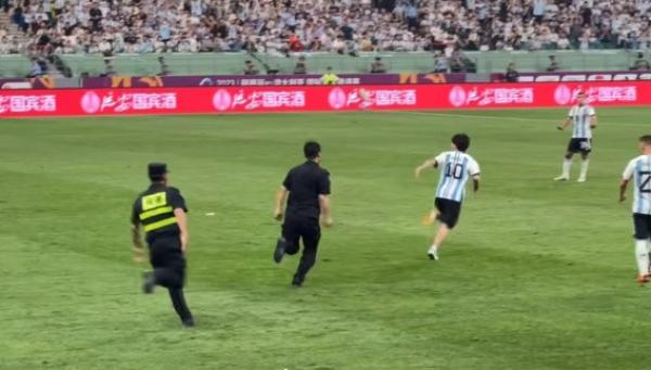 15日晚突然一穿着梅西球衣的疯狂中国球迷窜入场内拥抱他并与保安展开追逐。(图片来源:微博)