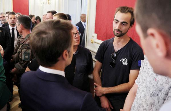 马克龙（左）与背包英雄亨利（右）交谈。（DENIS BALIBOUSE/POOL/AFP via Getty Images）