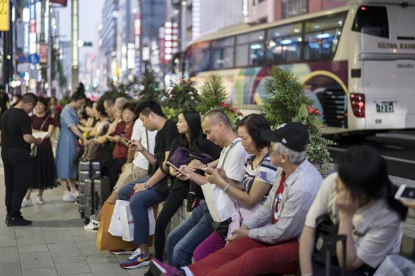 2019年10月2日,中国游客在日本东京银座购物区等待旅游巴士。(Tomohiro Ohsumi/Getty Images)