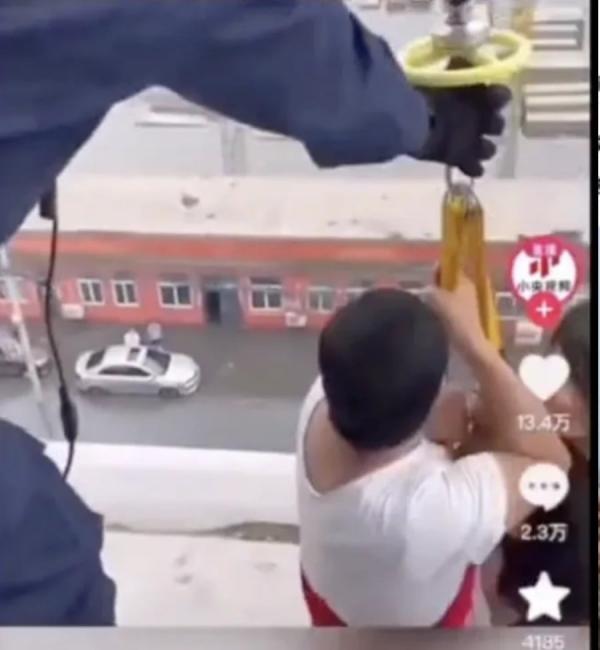 央视报导,救援队派遣直升机解救受困于顶楼的民众,却遭发现路面积水根本不及轿车轮胎一半。(图片来源:视频截图)