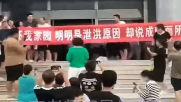 霸州市因泄洪而家园尽毁的灾民高举布条抗议。(图片来源:视频截图)