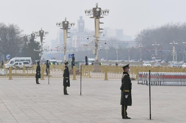 2021年3月11日,在人大会议闭幕前,大会堂附近的武警在天安门广场站岗。(NICOLAS ASFOURI/AFP via Getty Images)
