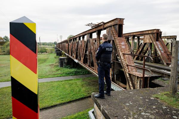 一名德国联邦警察在德国与波兰边境附近巡逻时站在移民经常使用的路线旁。(JENS SCHLUETER/AFP via Getty Images)
