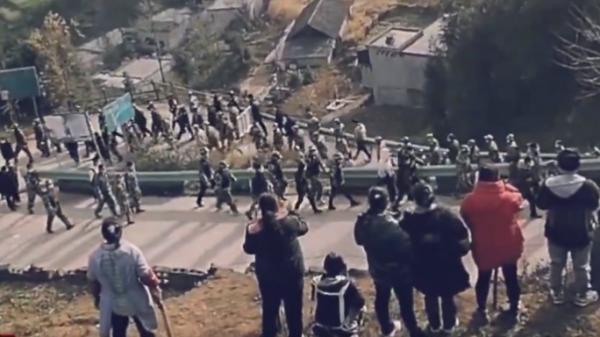 被“俘虏”的数百警察和公务员在贵州石灰窑村苗民们一片“嘘”声中低头离村。(图片来源:视频截图)