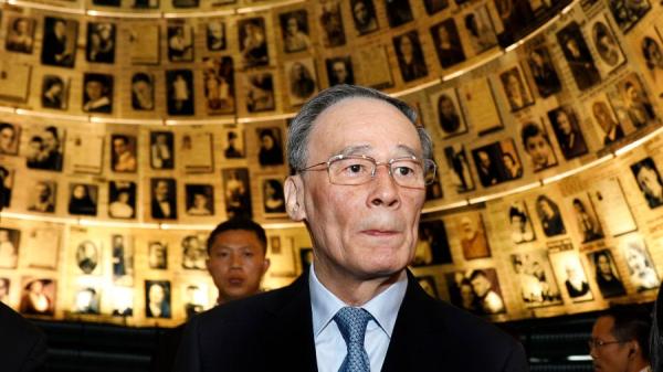 王岐山于2018年访问耶路撒冷的Yad Vashem大屠杀纪念馆，馆中挂有大屠杀中遇难的犹太受害者照片。