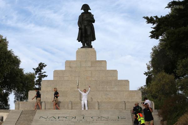 5月14日,法国空手道运动员亚历山德拉•费拉奇 (Alexandra Feracci)在科西嘉岛上拿破仑(Napoleon Bonaparte)雕像前,手持奥运火炬。(PASCAL POCHARD-CASABIANCA/AFP via Getty Images)