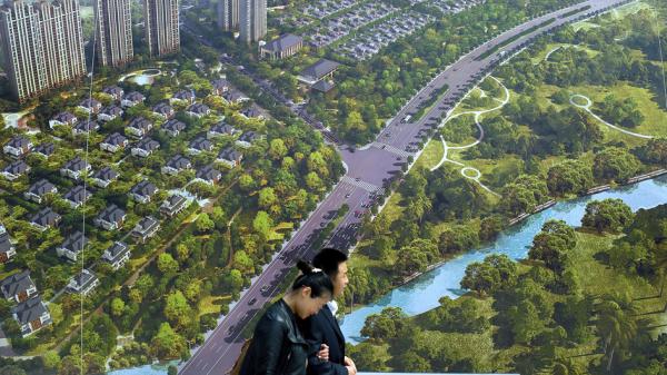 图为中国消费者路过一张巨幅房地产海报。(Hong Wu / Getty Images)