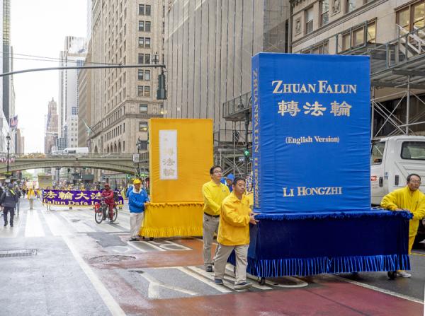 游行队伍里的《转法轮》英文和中文的图书模型。(摄影:Leo/看中国)