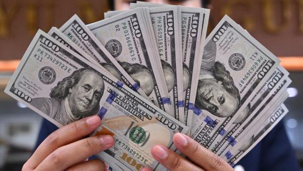 资料图，2024年5月2日，印尼雅加达一家货币兑换店的一名店员拿着一沓美元钞票。（图片来源：ADEK BERRY/AFP via Getty Images)）