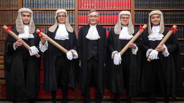 香港大律师、法官在庭上都有佩戴假发的传统。图为2023年资深大律师委任仪式上,终审法院首席法官张举能(中)与新获委任的资深大律师合照。(图片来源:香港政府新闻处)