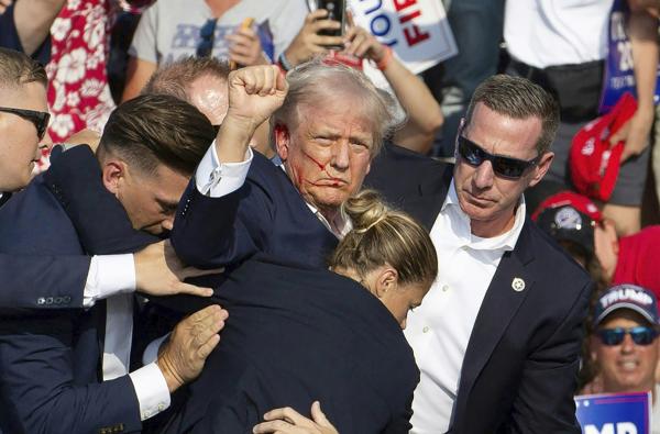 7月13日下午6点左右,美国前总统川普在宾州集会上中枪,随后在保镖拥簇下离开集会现场。(REBECCA DROKE/AFP via Getty Images)