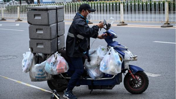2022年5月10日,阿里巴巴盒马生鲜超市的一名送货司机骑着摩托车在北京的街道上送货。(JADE GAO/AFP via Getty Images)