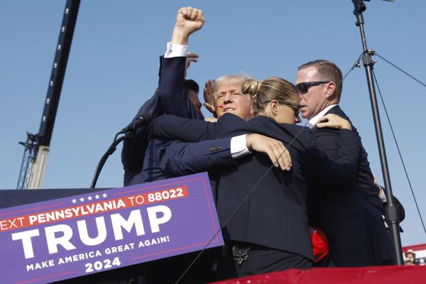 7月13日,川普在宾州竞选集会上中枪,在保镖拥簇下离开集会现场时,他挥舞着拳头。(Anna Moneymaker/Getty Images)