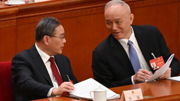 2024年3月5日,中共国务院总理李强(左)在北京人民大会堂举行的全国人民代表大会开幕式上与政治局常委蔡奇(右)交谈。