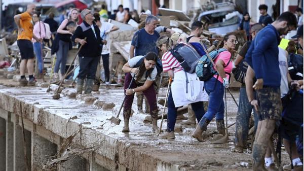 2024年11月1日,洪水摧毁了西班牙东部瓦伦西亚(Valencia)地区的派波尔塔镇,当地人和义工正在清除泥水。(JOSE JORDAN/AFP via Getty Images)