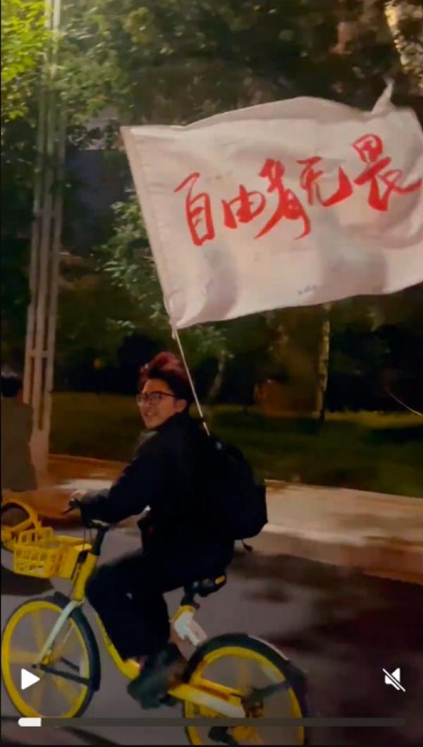 男学生扛着 “ 自由者无畏!” 旗帜(图片来源:视频截图)