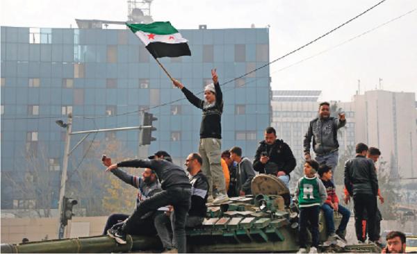 12月8日,叙利亚大马士革的倭马亚广场,人们对叙利亚政权倒台做出反应。(Ali Haj Suleiman/Getty Images)