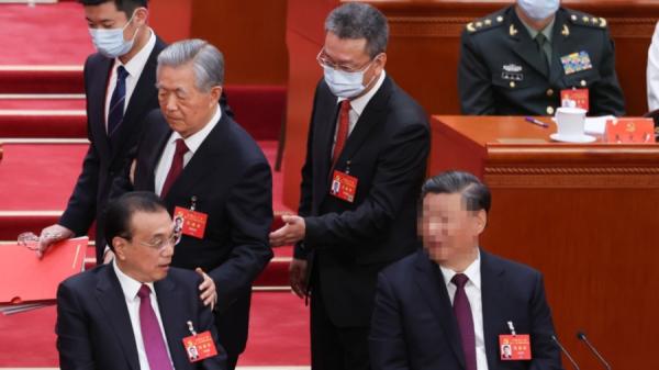 10月22日，在人民大会堂举行的中国共产党第二十次全国代表大会闭幕式上，前国家主席胡锦涛（中）被架离会场。（图片来源：Lintao Zhang/Getty Images）