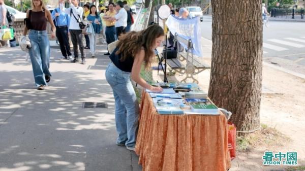在解体中共请愿书上签字的法国民众。(法国看中国记者站)