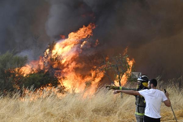 8月16日,在西班牙西北部,当地人和森林消防员正在努力扑灭一场野火。(MIGUEL RIOPA/AFP via Getty Images)