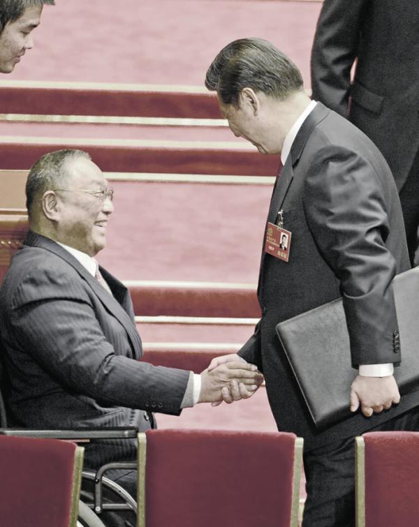 2012年中共十八大开幕会议中,习近平(右)主动与邓朴方握手。(GOH CHAI HIN/AFP via Getty Images)