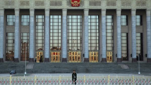 2013年11月12日,一名警察在北京人民大会堂外守卫,205名委员组成的中共中央委员会在此召开第三次全体会议。(图片来源:Getty Images)