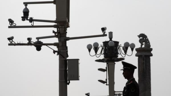 一名中共武警在北京天安门广场的监视器前站岗。(图片来源:STR/AFP via Getty Images)