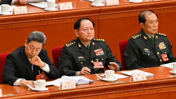 2025年3月5日,军委副主席张又侠(中)、何卫东(右)出席在北京人民大会堂举行的全国人民代表大会开幕会议。(图片来源:ADEK BERRY/AFP via Getty Images)