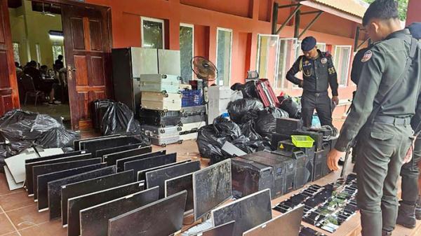 7月17日,柬埔寨军警正在查看在干丹省一处诈骗中心突袭行动中缴获的电脑、智能手机和其它设备。(STR/POOL/AFP via Getty Images)