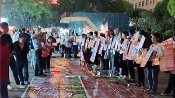 中国大陆失亲家属在街头举牌寻找失踪的家人。(图片来源:视频截图)