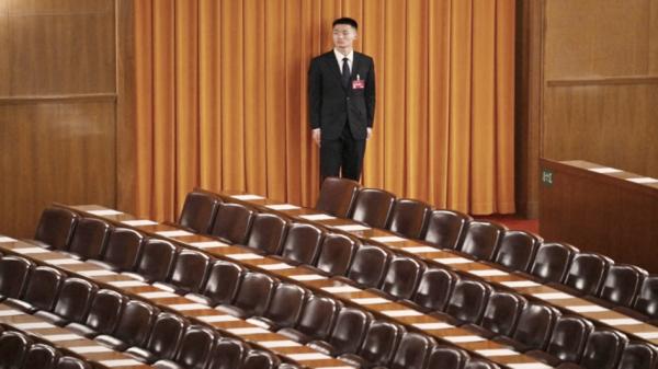 2024年3月，全国政协会议闭幕前，一名安保人员在看守北京人民大会堂的代表席。（Getty Images） 