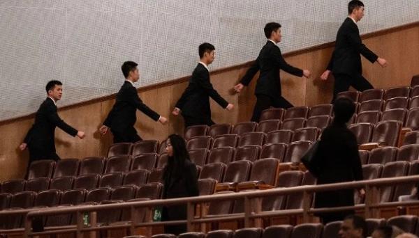 2026年3月12日，中共全国人民代表大会闭幕式开始前，在北京人民大会堂的安保人员走向各自岗位。（图片来源：Kevin Frayer/Getty Images）