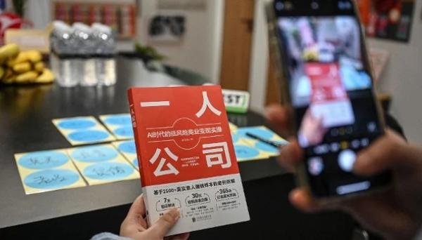 2026年4月12日，一人公司SoloNest的创始人戴凯伦（Karen Dai）在上海的一间会议室里为她的新书《一人公司》（One Person Company）拍照。许多中国年轻人担心35岁以后会在职场上遭遇年龄歧视，因此越来越多地创办“一人公司”，让人工智能承担大部分工作。（图片来源：Jade GAO/AFP via Getty Images）