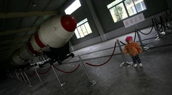 2007年10月20日，四川省西昌市一处展览厅内，一名孩童在长征三号火箭前玩耍。（图片来源：Photo by China Photos/Getty Images）