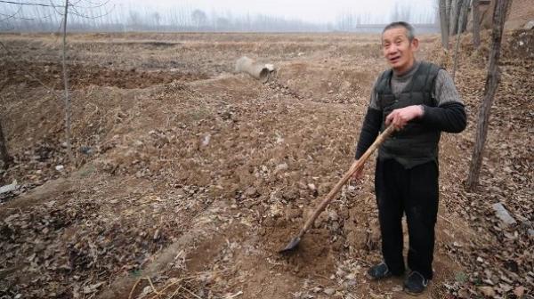 2009年2月24日，在山东省德州郊外的一片干涸田地里，棉农周卫东正手持铁锹劳作。（图片来源：FREDERIC J.BROWN/AFP via Getty Images）
