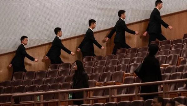 2026年3月12日，中共全国人民代表大会闭幕式开始前，在北京人民大会堂的安保人员走向各自岗位。（图片来源：Kevin Frayer/Getty Images）