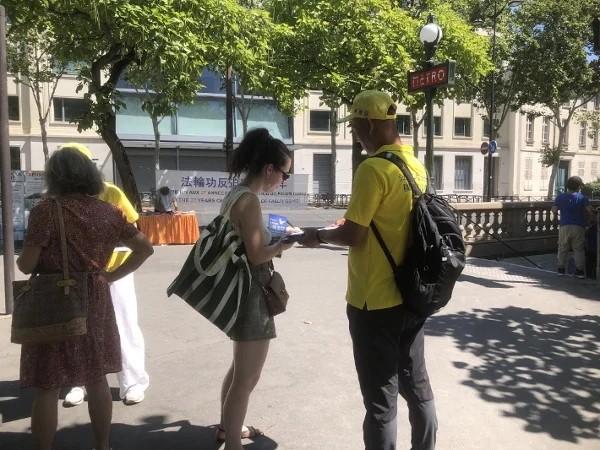 过往行人在“解体中共”请愿书上签字。(图片来源:法国看中国记者站)
