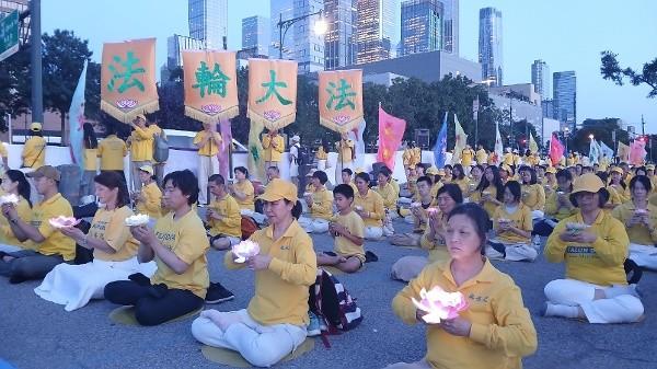 在反迫害27周年集会上,法轮功学员手举莲花,悼念被中共迫害致死的法轮功学员。(摄影:Daniel/看中国)