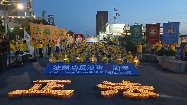 在反迫害27周年集会上,法轮功学员手举莲花,悼念被中共迫害致死的法轮功学员。(摄影/看中国/Daniel)
