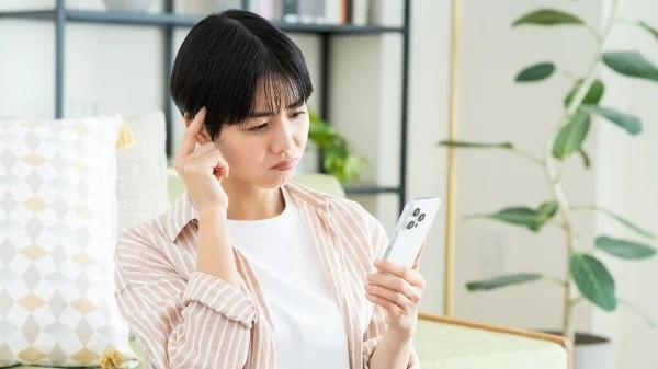 女子看着手机思考    （图片来源：翻拍）