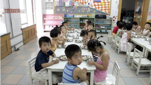 2004年8月5日，学生们在北京的一家幼儿园里享用早餐。（图片来源：GOH Chai Hin/AFP via Getty Images）