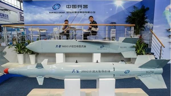 2012年11月12日,在珠海第九届中国国际航空航天博览会开幕前夕,几名男子坐在中国北方工业集团有限公司(中国兵器工业集团)的导弹模型展台旁。(图片来源:PHILIPPE LOPEZ/AFP via Getty Images)
