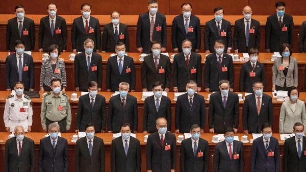 2020年5月22日，在北京人民大会堂举行的中共全国人大会议开幕式上，全体佩戴口罩的中共代表起立。（图片来源：Kevin Frayer/Getty Images）